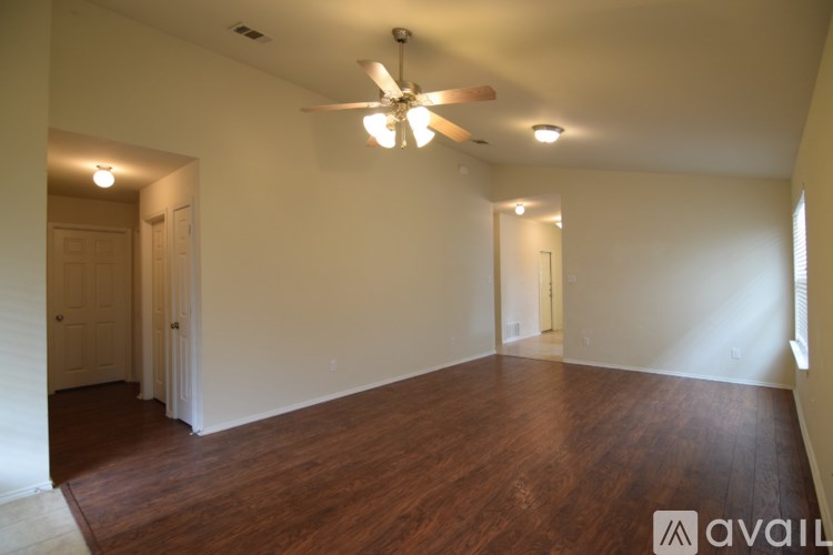 A room with wooden floors and a ceiling fan.