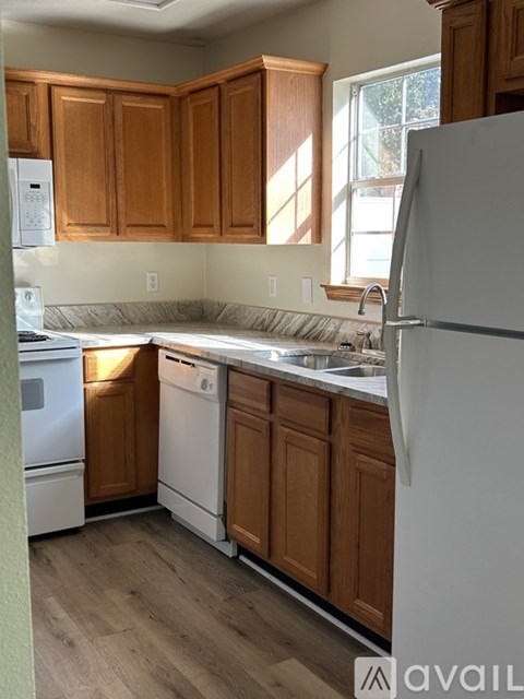 A kitchen with wooden cabinets and white appliances.