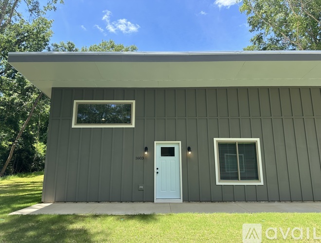 A house with a blue door and a window is for sale.