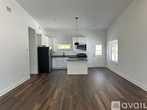A kitchen with white cabinets and a black fridge is available.
