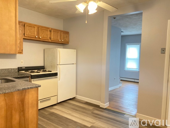 A kitchen with wooden cabinets and a white refrigerator.