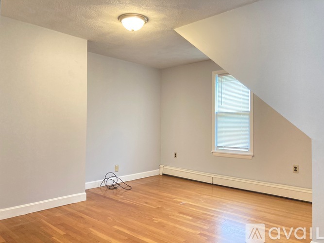 A room with a window and wooden floors.