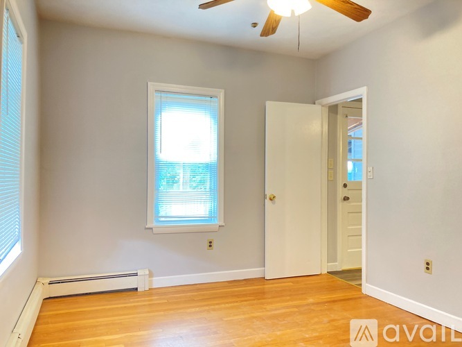 A room with a window and a door is available for rent.