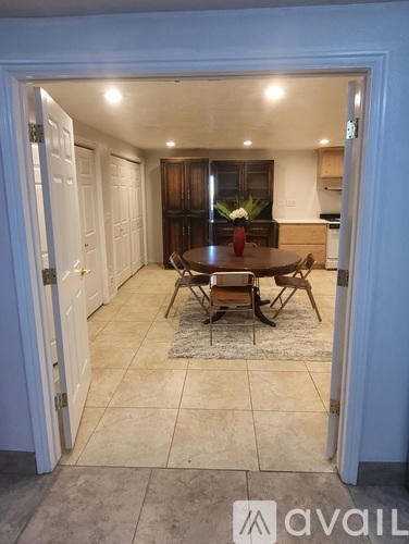 A dining room with a table and chairs is visible through an open door.