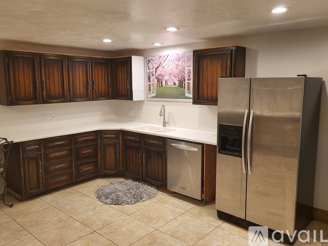 A kitchen with wooden cabinets and a stainless steel refrigerator.
