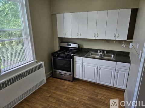 A kitchen with white cabinets and a black stove top oven.