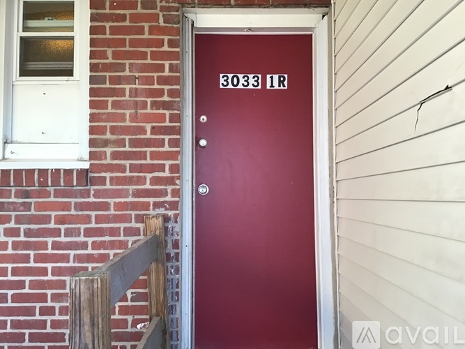 A red door with the number 3033 on it.