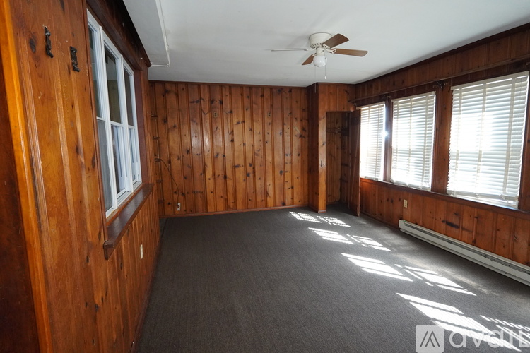 A room with wooden walls and a ceiling fan.