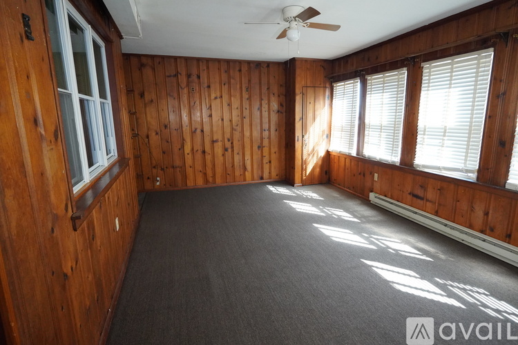 A room with wooden walls and a ceiling fan.