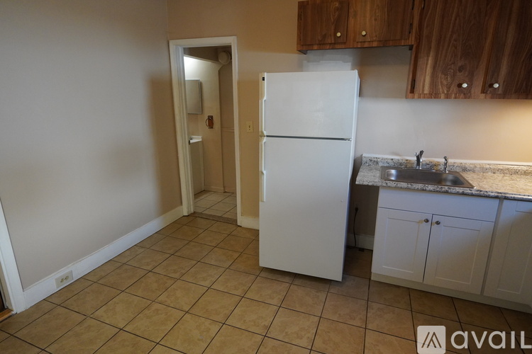 A kitchen with a white refrigerator and cabinets.