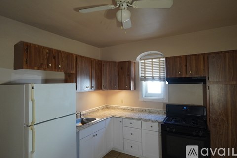 A kitchen with wooden cabinets and a white refrigerator.