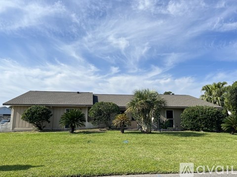A house with a grey roof and a green lawn in front.