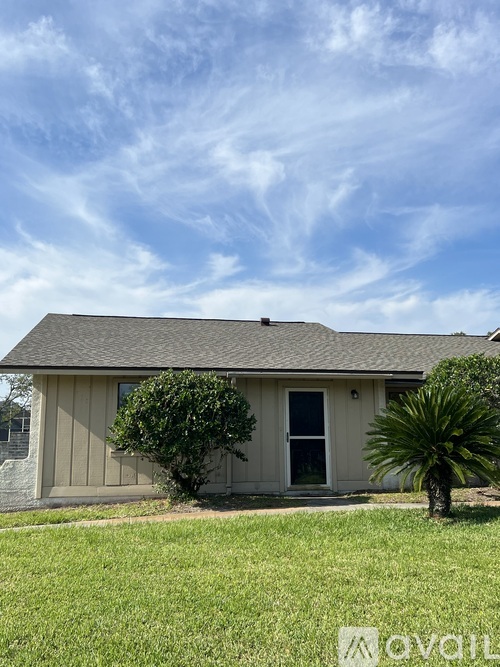 A house with a grey roof and a green lawn.
