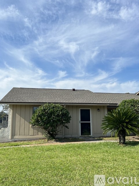 A house with a grey roof and a green lawn.