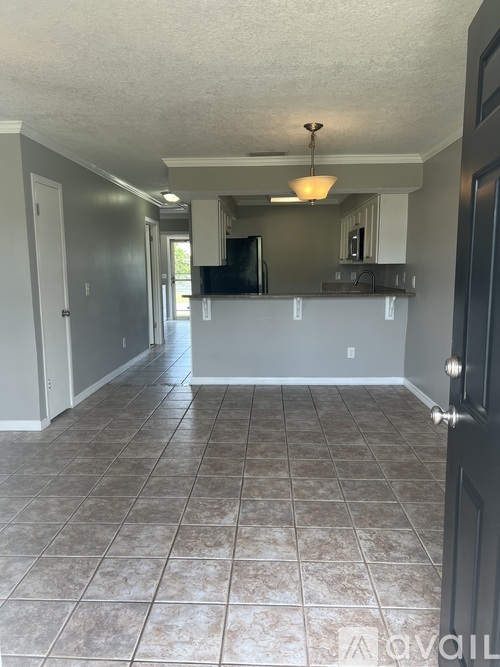 A room with tile flooring and a door on the right.