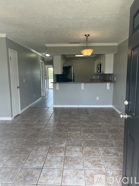 A room with tile flooring and a door on the right.
