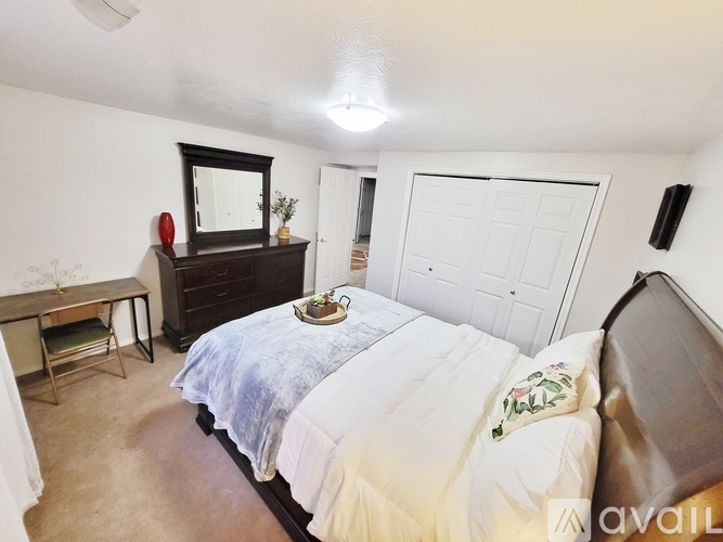A bedroom with a bed, dresser, and mirror.