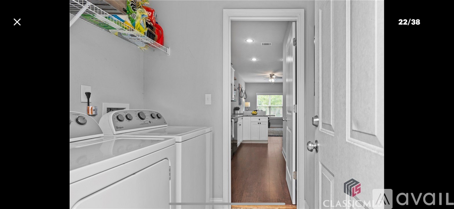 A white kitchen with a washer and dryer stacked on top of each other.