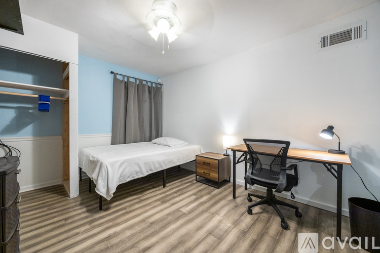A bedroom with a bed, desk, and chair.