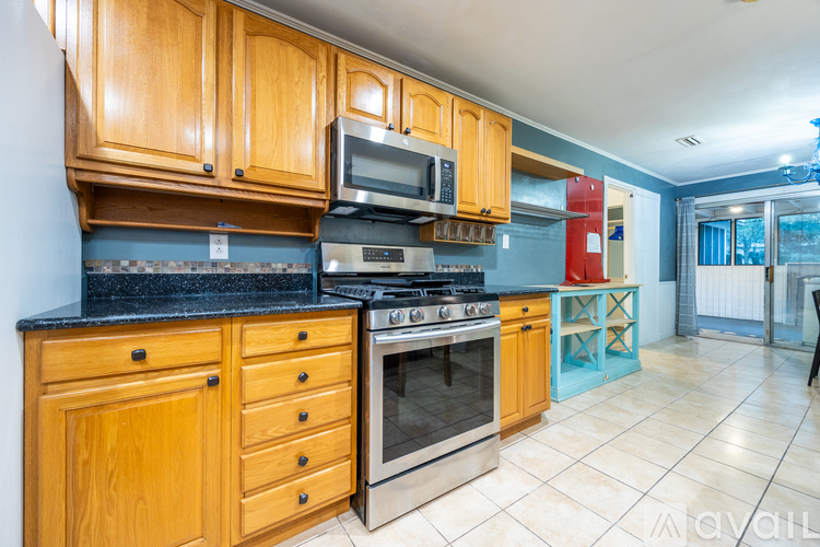 A kitchen with wooden cabinets and a black countertop.