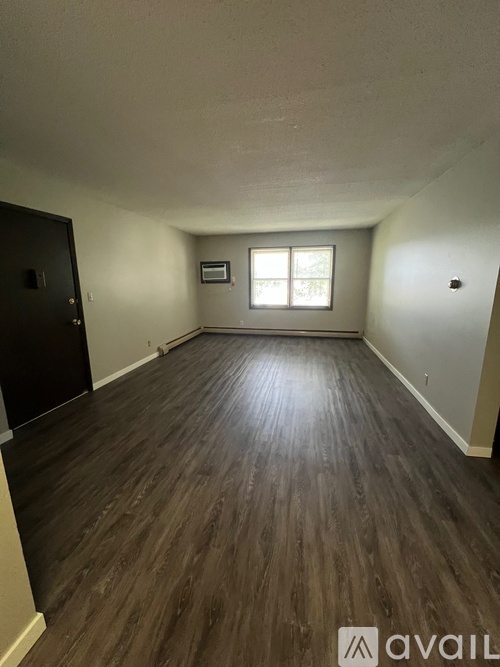 A room with wooden flooring and a window.