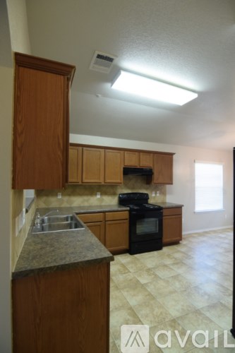 A kitchen with wooden cabinets and a black oven.