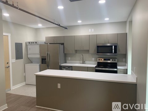 A kitchen with a white counter top and brown cabinets.