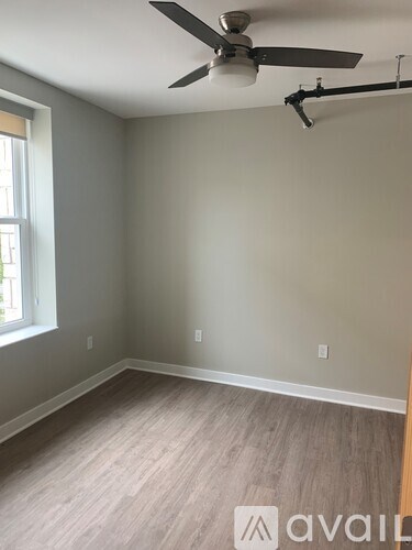 A room with a ceiling fan and light fixture.