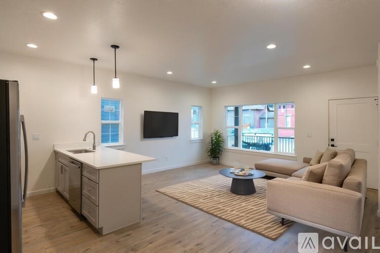 A modern kitchen with a refrigerator, sink, and a large window overlooking the city.