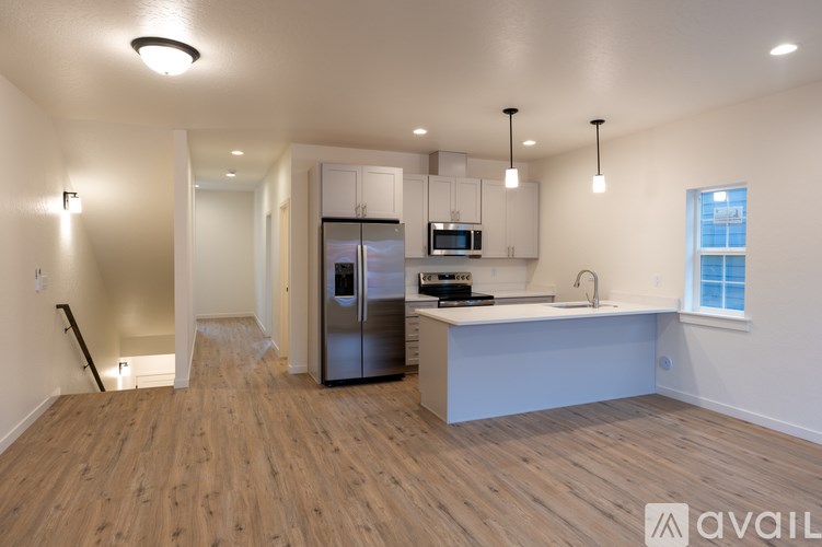 A kitchen with a refrigerator, sink, and cabinets.