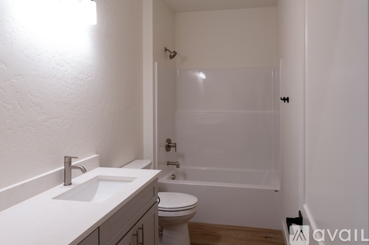 A white bathroom with a toilet, sink, and bathtub.