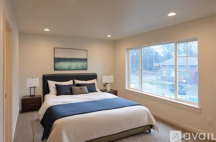 A bedroom with a large bed and a window overlooking a street.