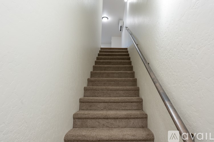 A staircase with a metal handrail on the side.
