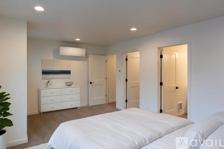 A bedroom with a large bed, a dresser, and a mirror.