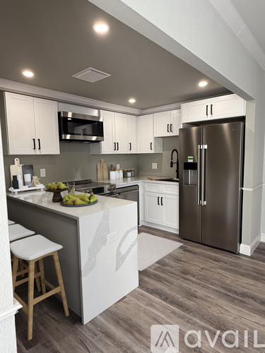 A kitchen with white cabinets and a wooden island.
