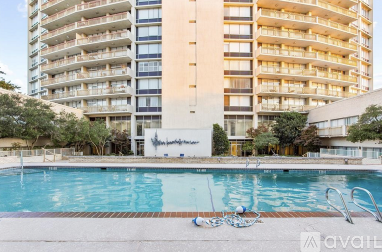 A large swimming pool in front of a tall apartment building.