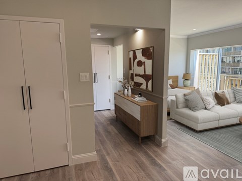 A modern living room with a white sofa and a wooden cabinet.