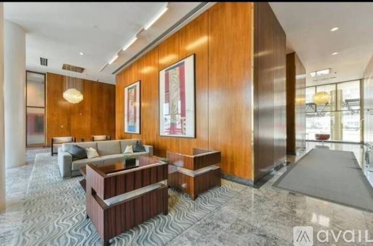 A spacious living room with a wooden floor and a large painting on the wall.