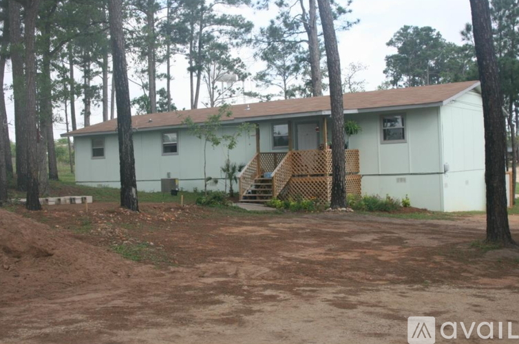 A house with a brown roof is surrounded by trees.