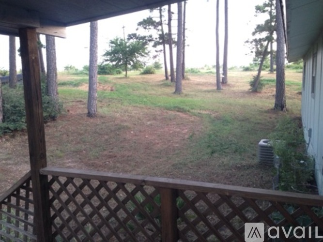 A view from a porch looking out to a yard with trees.