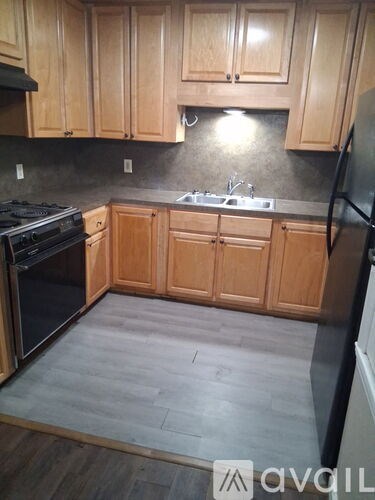 A kitchen with wooden cabinets and a black countertop.