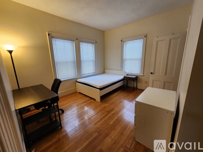 A room with a bed, desk, and chair.