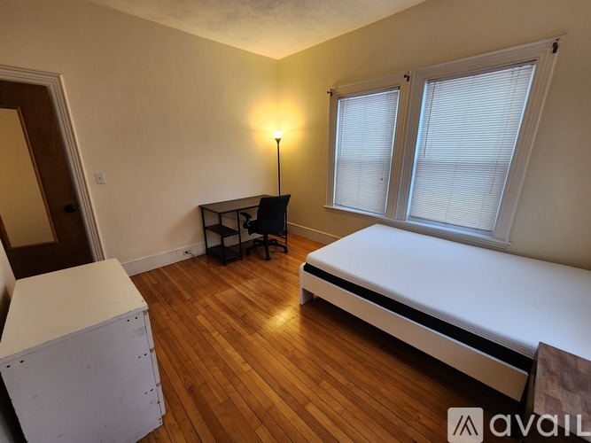 A bedroom with a bed, desk, and chair.