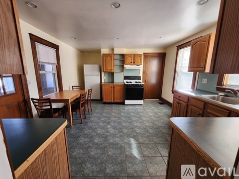 A kitchen with wooden cabinets and a black countertop.