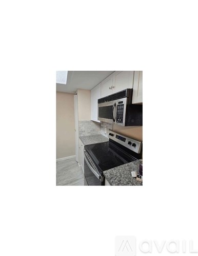A kitchen with a microwave and oven built into the cabinetry.