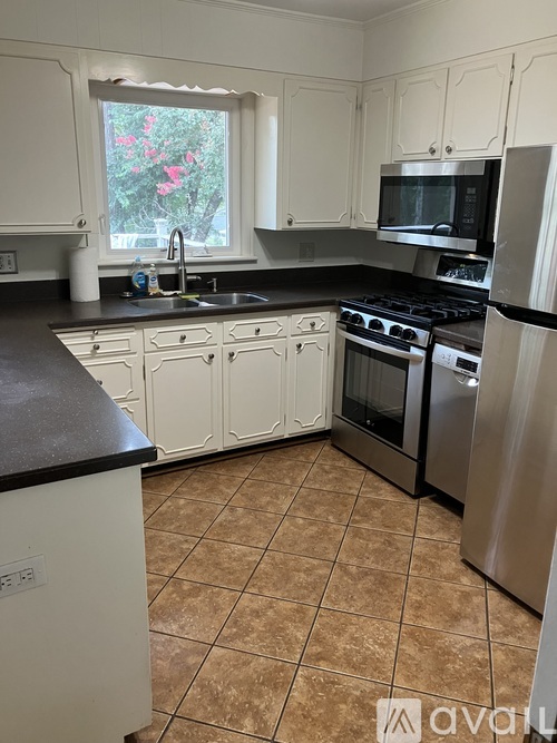 A kitchen with white cabinets and a black countertop.