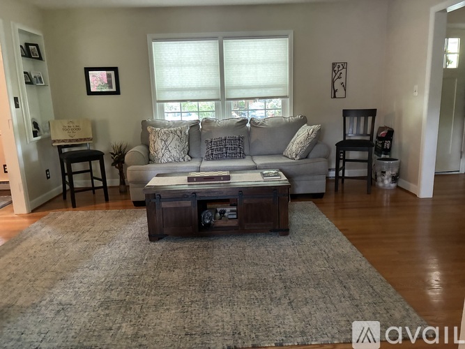 A living room with a grey couch and a wooden coffee table.