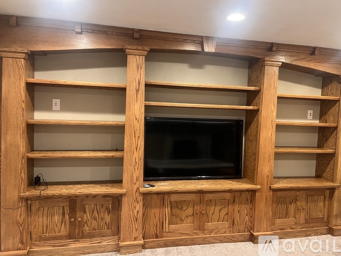 A wooden entertainment center with a flat screen TV built in.