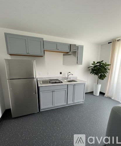 A kitchen with a refrigerator, sink, and cabinets.