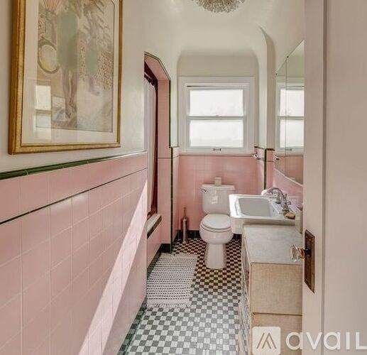 A bathroom with pink walls and a checkered floor.